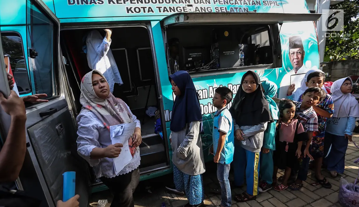 Anak-anak antre membuat Kartu Identitas Anak (KIA) di mobil Disdukcapil Pondok Aren, Tangerang Selatan, Jumat (16/11). Pada tahun anggaran 2018 disediakan 130 ribu keping blangko KIA dari APBD dan 40 ribu dari APBN. (Liputan6.com/Fery Pradolo)