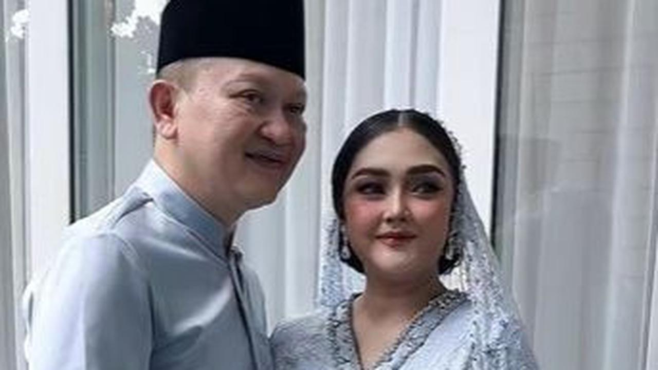 Pada momen itu Suci terlihat cantik mengenakan busana berwarna biru. Sang suami pun nampak gagah dengan baju warna senada ditambah peci hitam.