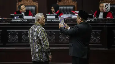 Marsudi Wahyu Kisworo, ahli yang dibawa oleh tim hukum KPU disumpah sebelum memberikan keterangan dalam sidang lanjutan sengketa Pilpres 2019 di Gedung MK, Jakarta, Kamis (20/6/2019). Sidang mendengarkan keterangan saksi dan ahli dari pihak termohon, yaitu KPU RI. (Liputan6.com/Faizal Fanani)