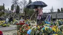 Tetiana Rurak (25) mengunjungi makam suaminya yang merupakan seorang tentara, Volodymyr Rurak, bersama putrinya yang berusia satu setengah tahun setelah suaminya itu terbunuh dalam perang dengan Rusia di pemakaman Lychakiv, Lviv, Ukraina, Selasa (5/4/2022). (AP Photo/Nariman El-Mofty)