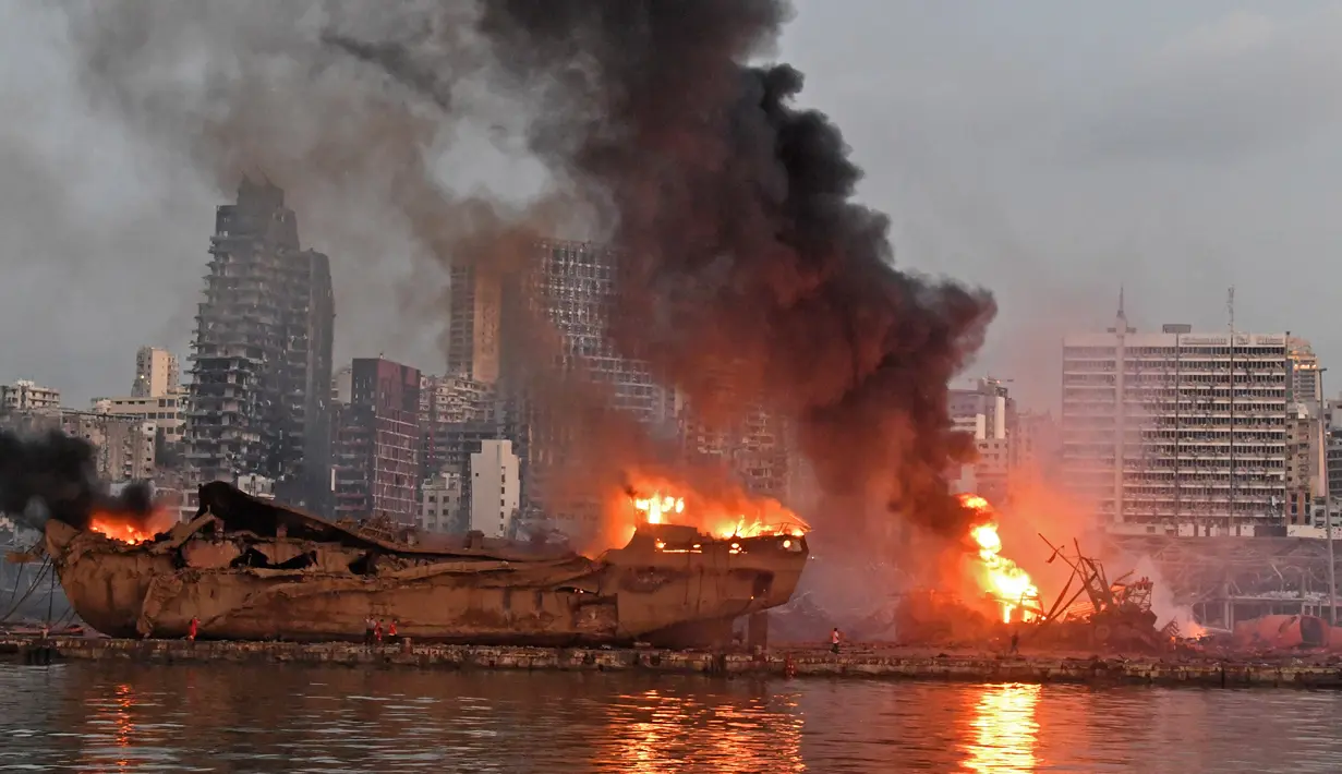 Sebuah kapal besar yang terbakar setelah ledakan besar di pelabuhan Kota Beirut, Lebanon (5/8/2020). Kuatnya ledakan di Beirut sampai kapal tersebut terangkat ke Daratan dan hancur. (AFP Photo)