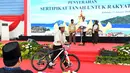 Warga membawa hadiah sepeda yang diberikan oleh Presiden Jokowi saat membagikan sertifikat di GOR Way Handak, Kalianda, Lampung Selatan, Lampung, Minggu (21/1). (Liputan6.com/Pool/Laily Rachev-Biro Pers Setpres)