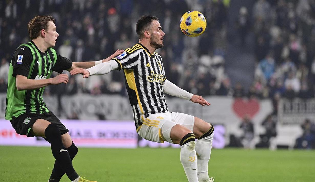 Pemain Juventus, Filip Kostic, berebut bola dengan pemain Sassuolo, Ryan Flamingo, dalam laga Serie A 2023/2024 giornata 20 yang dihelat di Allianz Stadium, Rabu (17/1/2024). (Marco Alpozzi/LaPresse via AP)