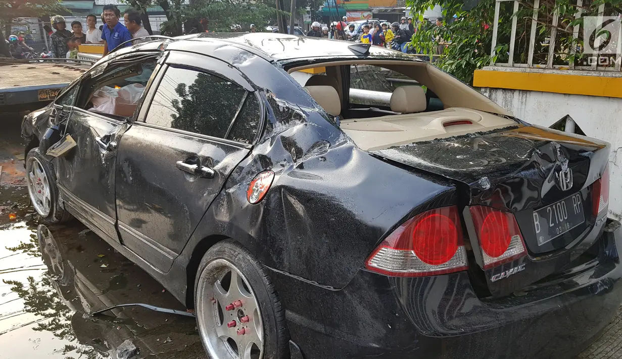 Kondisi sebuah mobil yang mengalami kecelakaan tunggal di kawasan Pasar Minggu, Jakarta Selatan, Sabtu (8/6/2019). Mobil yang nyaris tercebur sungai itu dikendarai seorang pemuda yang nekat melakukan aksi kebut-kebutan saat jalanan ibu kota lengang. (Liputan6.com/Herman Zakharia)