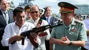 Presiden Filipina Rodrigo Duterte bersama Menhan Rusia, Sergei Shoigu (kanan) memegang senapan serbu AK-47 sumbangan dari Rusia di atas kapal perusak Rusia Admiral Panteleyev di pelabuhan Metro Manila, Filipina (25/10). (AFP Photo/Robinson Ninal)