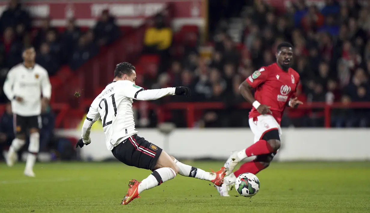 Gelandang Manchester United, Antony menembak bola saat bertanding melawan Nottingham Forest pada semifinal leg pertama Piala Liga Inggris, Kamis (26/1/2023). Manchester United menang telak atas Nottingham Forest dengan skor 3-0. (Tim Goode/PA via AP)