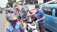 Bupati Banyumas, Achmad Husein dan Ketua Tim Penggerak PKK Banyumas membagikan hand sanitizer berbahan baku ciu dan masker gratis untuk masyarakat. (Foto: Liputan6.com/Humas Pemkab Banyumas/Muhamad Ridlo)