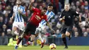 Penyerang Manchester United, Marcus Rasford, berusaha melewati pemain Huddersfield pada laga Premier League di Stadion Old Trafford, Rabu (26/12). Manchester United menang 3-1 atas Huddersfield. (AP/Martin Rickett)