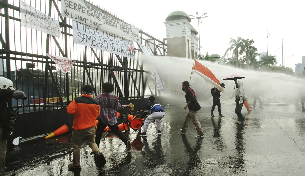 Aparat kepolisian melepaskan water canon untuk membubarkan massa aksi demo mahasiswa di depan Gedung DPR, Jakarta, Senin (11/4/2022). Mahasiswa yang tergabung dalam aliansi BEM SI menggelar unjuk rasa besar-besaran di depan Gedung DPR/MPR RI, Senin ini. (Liputan6.com/Angga Yuniar)