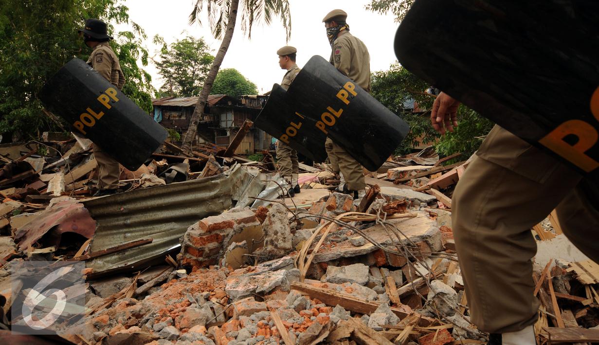Petugas Satpol PP bersiap mengamankan proses penggusuran rumah warga di Kampung Pulo, Jakarta, Kamis (20/8/2015). 2200 personil gabungan dari Kepolisian dan satpol PP dikerahkan untuk mengamankan penggusuran tersebut. (Liputan6.com/Helmi Fithriansyah)