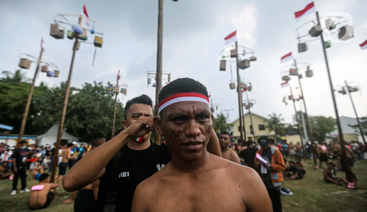 Seorang peserta mengikuti lomba panjat pohon pinang di Pantai Festival Ancol, Jakarta, Rabu (17/8/2022). Sebanyak 45 pohon pinang siap dipanjat oleh pengunjung di Pantai Festival Ancol  untuk memeriahkan Hari Ulang Tahun (HUT) Ke-77 Republik Indonesia. (Liputan6.com/Faizal Fanani)