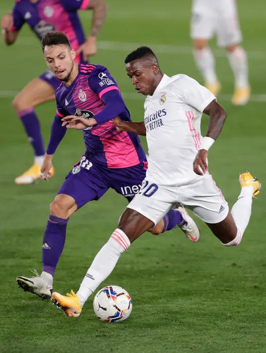 Penyerang Real Madrid, Vinicius Junior  pemain Valladolid, Oscar Plano pada lanjutan La Liga Spanyol di stadion Alfredo, Rau (30/9/2020). Real Madrid menekuk Real Valladolid denga skor 1-0. (AP Photo/Manu Fernandez)