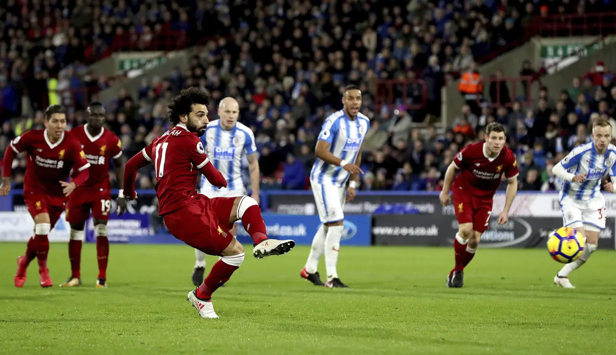 Mohamed Salah saat mencetak gol lewat penalti ke gawang Huddersfield Town pada lanjutan Premier League di John Smith's Stadium, Huddersfield, (30/1/2018). Liverpool menang 3-0. (Martin Rickett/PA via AP)