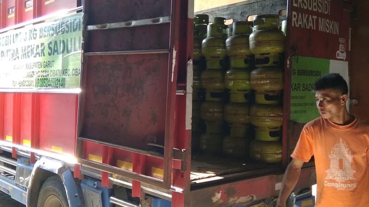 Salah seorang pegawai agen gas LPG 3 kg tengah menaikan gas melon ke salah satu mobil angkutan gas bersubisi di Garut, Jawa Barat. (Liputan6.com/Jayadi Supriadin)