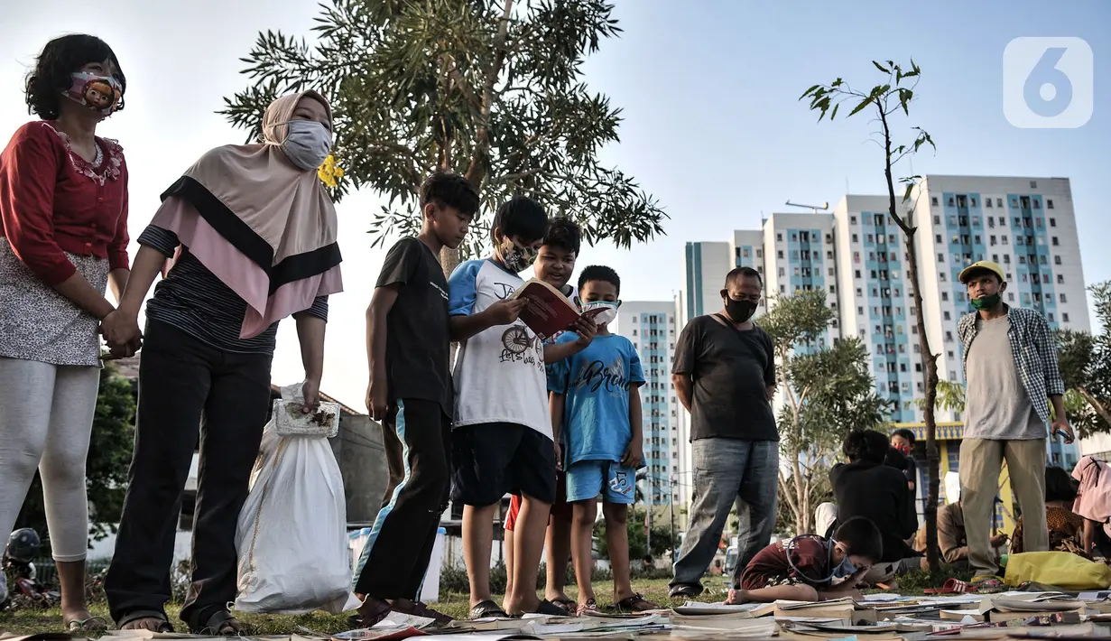 Anak-anak dan orangtua memilih buku saat kehadiran Perpustakaan Keliling di kawasan Kampung Melayu, Jakarta, Minggu (16/8/2020). Perpustakaan Keliling menyajikan berbagai buku bacaan yang dapat dimiliki secara gratis oleh anak-anak. (merdeka.com/Iqbal S. Nugroho)