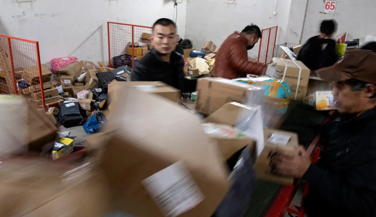 Para pekerja ekspedisi sibuk memilah paket untuk dikirim ke pelanggan saat Singles Day di Beijing, China, Senin (11/11/2019). Singles Day menjadi pesta belanja online terbesar di dunia. (NOEL CELIS/AFP)