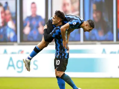 Striker Inter Milan, Lautaro Martinez, melakukan selebrasi bersama Achraf Hakimi usai mencetak gol ke gawang Crotone pada laga Liga Italia di Stadion Giuseppe Meazza, Minggu (3/1/2021). Inter Milan menang dengan skor 6-2. (AP/Antonio Calanni)
