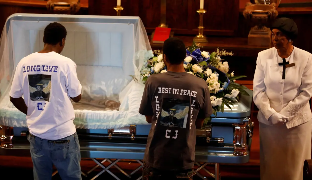 Dua orang teman melihat jenazah Carnell Snell Jr yang ditembak mati oleh Polisi Los Angeles, di Los Angeles, California, AS, Sabtu (8/10) Polisi mengatakan terpaksa menembak karena Snell hendak menyerang mereka dengan senpi.  (REUTERS / Jonathan Alcorn)