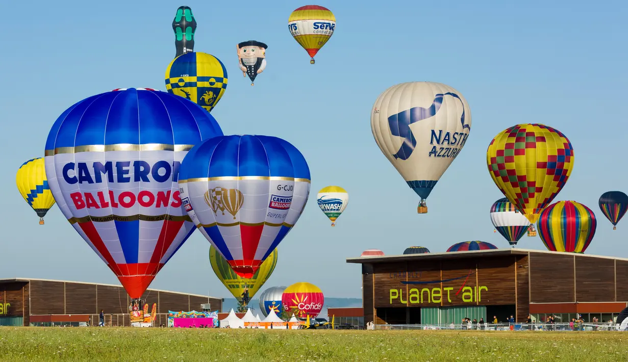 Balon udara terbang di pangkalan udara Chambley-Bussieres, Hagéville, Prancis, Senin (29/7/2019). Lebih dari 400 balon udara menghiasi langit Prancis dalam acara ini. (Jean-Christophe VERHAEGEN/AFP)