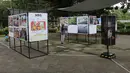 Bertajuk Haluan Merah Putih, pameran karya jurnalistik sebagai upaya menghadirkan informasi publik di ruang terbuka, kegiatan ini terbuka untuk umum dan berlangsung hingga 1 Januari 2026. Tampak dalam foto, pengunjung menyaksikan karya foto jurnalistik dalam pameran Haluan Merah Putih Roadshow yang digelar di Selasar Kantin Taman Margasatwa Ragunan, Jakarta Selatan, Rabu (24/12/2025). (merdeka.com/magang/Rendi Saputra)