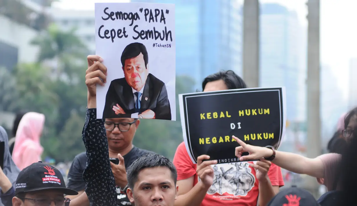 Aktivis Koalisi Masyarakat Sipil Anti Korupsi menunjukkan tulisan saat aksi Indonesia Berkabung di kawasan Bundaran HI Jakarta, Minggu (1/10). Aksi ini reaksi atas dikabulkannya permohonan praperadilan Setya Novanto. (Liputan6.com/Helmi Fithriansyah)