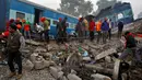 Petugas mencari korban yang masih tersisa di antara bangkai kereta api setelah terjadi kecelakaan di Pukhrayan, Kanpur, India (21/11). Menurut keterangan kepolisian setempat, korban yang meninggal tercatat lebih dari 100 orang. (Reuters/ Jitendra Prakash)