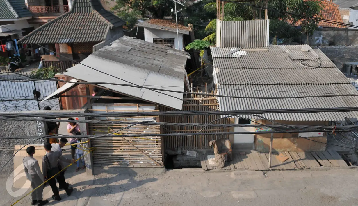 Polisi memasang garis polisi di sekitar Bedeng Agus di kawasan Kalideres, Jakarta, Minggu (11/10/2015). Menurut warga, bedeng tersebut kepap dijadikan arena kumpul para ABG.(Liputan6.com/Gempur M Surya)