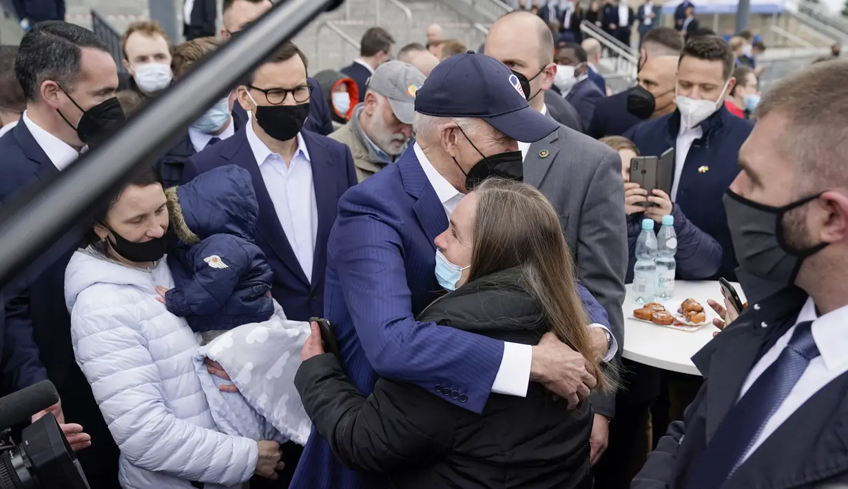 Presiden Amerika Serikat Joe Biden memeluk seorang gadis saat bertemu dengan pengungsi Ukraina dan pekerja bantuan kemanusiaan pada kunjungan ke PGE Narodowy Stadium di Warsawa, Polandia, 26 Maret 2022. (AP Photo/Evan Vucci)