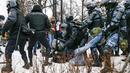 Polisi anti huru hara menahan seorang demonstran dengan wajah berdarah selama protes terhadap pemenjaraan pemimpin oposisi Alexei Navalny di alun-alun Pushkin di Moskow, Rusia, Sabtu (23/1/2021). (AP Photo/Alexander Zemlianichenko)