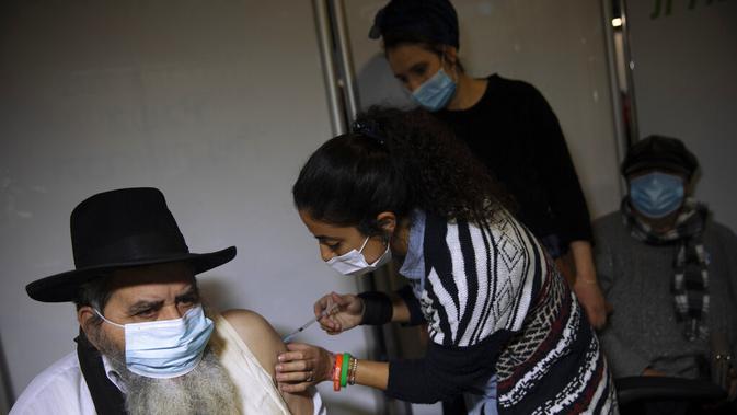 Seorang pria menerima vaksin virus corona COVID-19 dari staf medis di Pusat Vaksinasi COVID-19, Yerusalem, Senin (4/1/2021). Israel telah memberikan vaksin virus corona COVID-19 kepada lebih dari satu juta orang. (AP Photo/Oded Balilty)