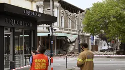 Petugas darurat mensurvei kerusakan di Melbourne, di mana puing-puing berserakan setelah sebagian tembok jatuh dari gedung saat gempa, Rabu (22/9/2021). Gempa magnitudo 5,8 melanda dekat Melbourne dan guncangannya terasa di sejumlah wilayah di Australia pada Rabu pagi. (James Ross/AAP Image via AP)