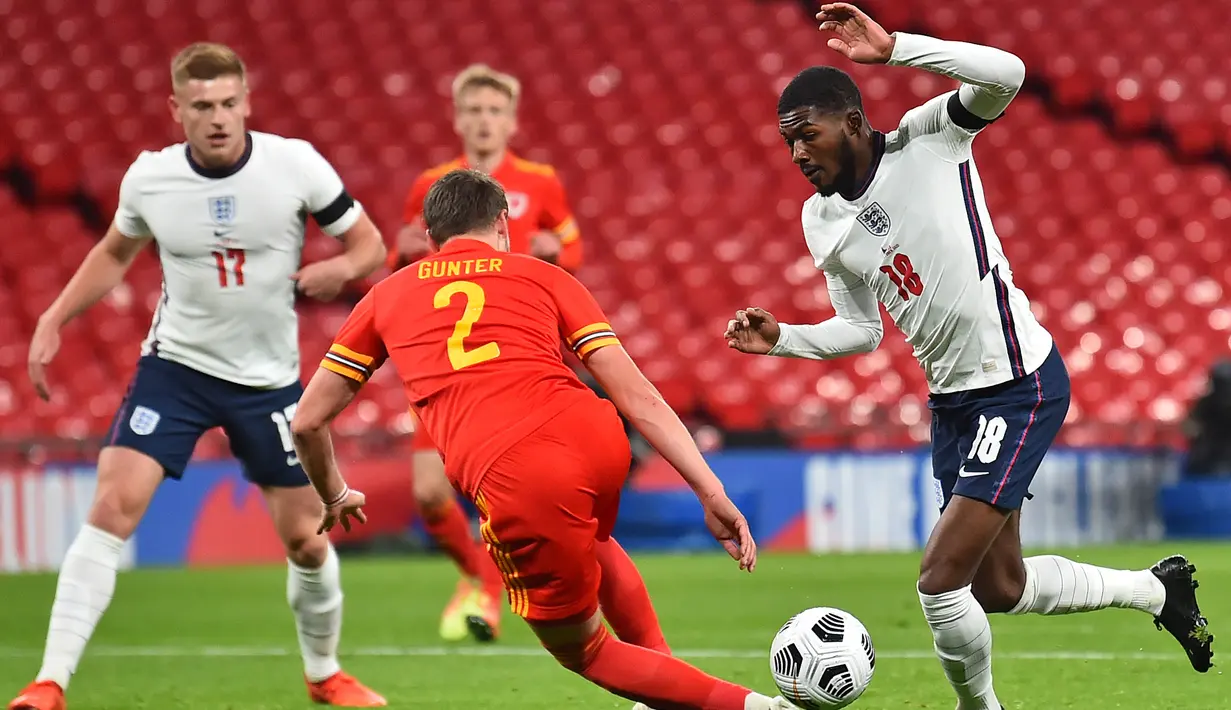 Bek Inggris, Ainsley Maitland-Niles, berebut bola dengan bek Wales, Chris Gunter, pada laga persahabatan di Stadion Wembley, Jumat (9/10/2020) dini hari WIB. Inggris menang 3-0 atas Wales. (AFP/Glyn Kirk/pool)
