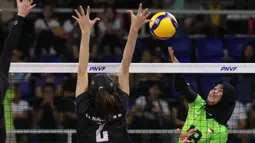 Pemain Timnas voli putri Indonesia, Putri Agustin (kanan) melepaskan spike yang berusaha diblok pemain Singapura, Nadja Kim Schmidt pada laga Grup B AVC Challenge Cup 2024 di Rizal Memorial Coliseum, Manila, Filipina, Jumat (24/5/2024). Indonesia menang 3-0 (25-14, 25-13, 25-14). (Asian Volleyball Confederation)