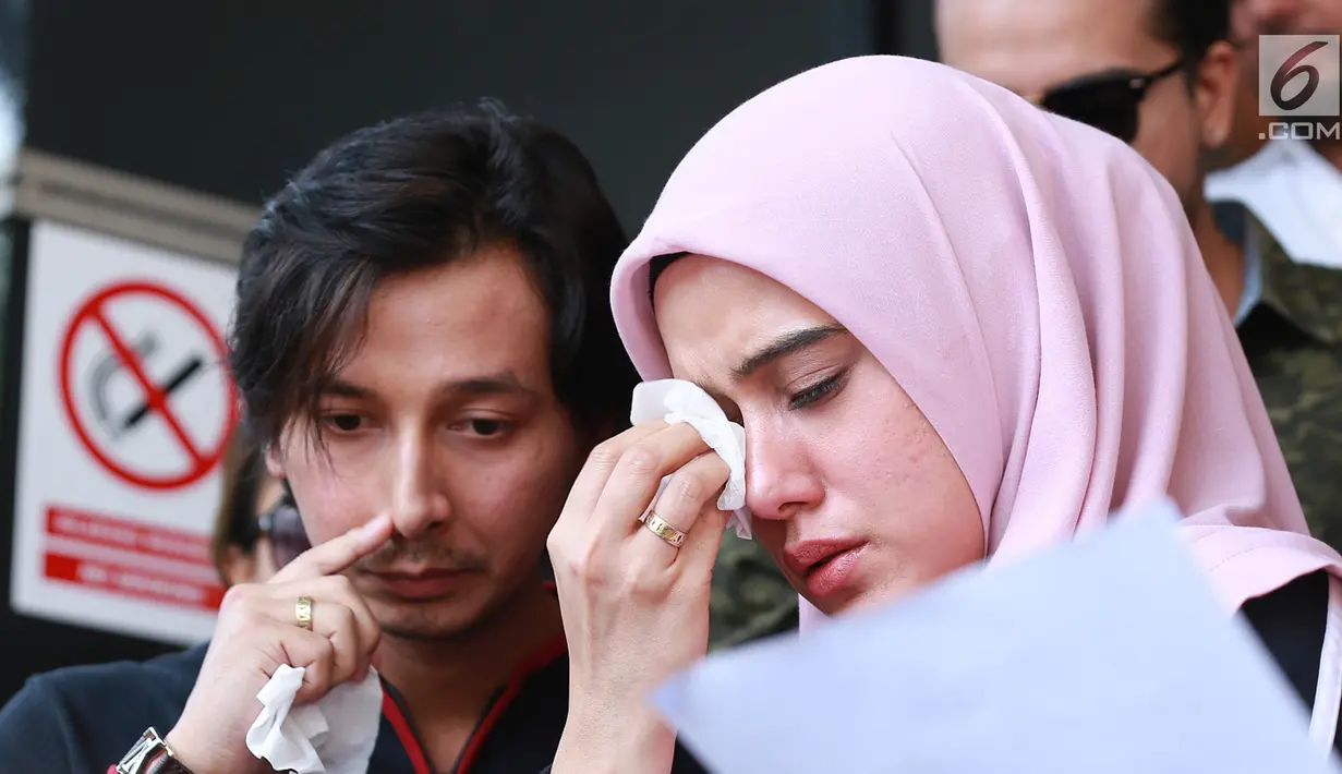 Fairuz A Rafiq didampingi suami Sonny Septian menangis saat memberikan keterangan pers di Polda Metro Jaya, Jakarta Selatan, Senin (1/7/2019). Fairuz melaporkan Galih Ginanjar dengan pasal pencemaran nama baik yang membongkar masa lalu pernikahan mereka. (Fimela.com/Deki Prayoga)