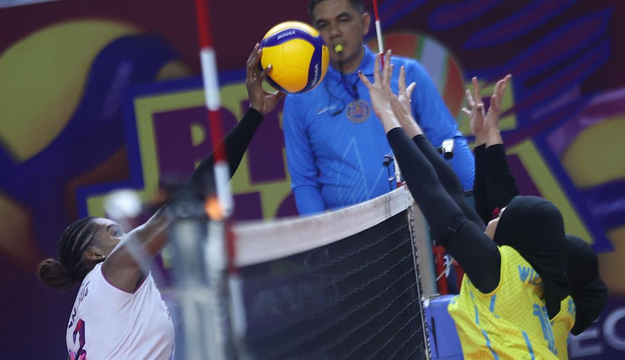 Pemain asing Jakarta Popsivo Polwan Yonkaira Pena melakukan pukulan melewati dua blok Jakarta Electric PLN dalam lanjutan putaran kedua Proliga 2026 di GOR Utama, Bojonegoro pada Jumat (13/02/2026).