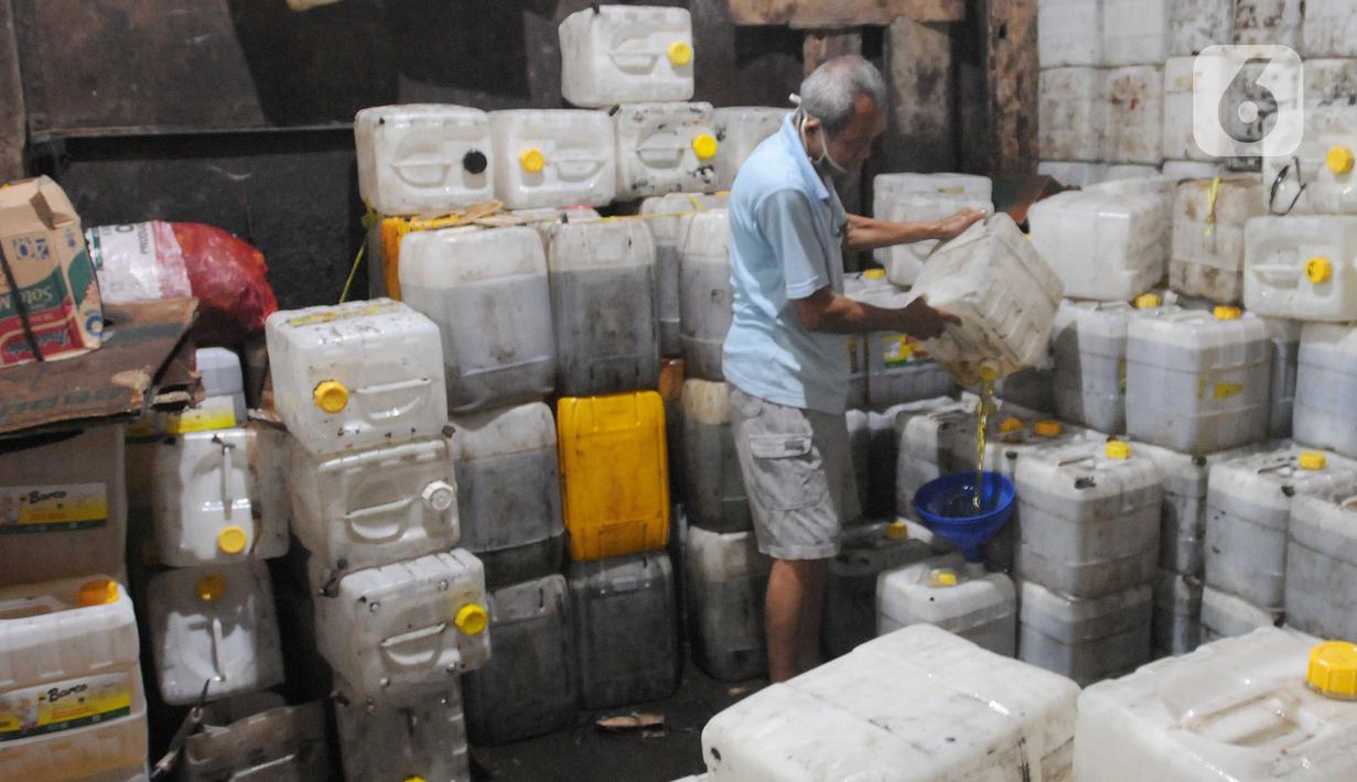 Pedagangan menuang minyak goreng curah ke dalam jerigen untuk pembeli di Jalan MA Salmun, Bogor, Kamis (31/3/20222). Antrean yang sudah terjadi sudah lebih dari dua pekan ini menurut pedagang disebabkan sulitnya mencari minyak goreng curah di Kota Bogor. (merdeka.com/Arie Basuki)