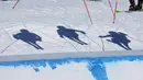 Bayangan para pemain ski di lapangan selama final lintas putra Olimpiade Musim Dingin 2022 di Zhangjiakou, China, Jumat (18/2/2022).  (AP Photo/Gregory Bull)