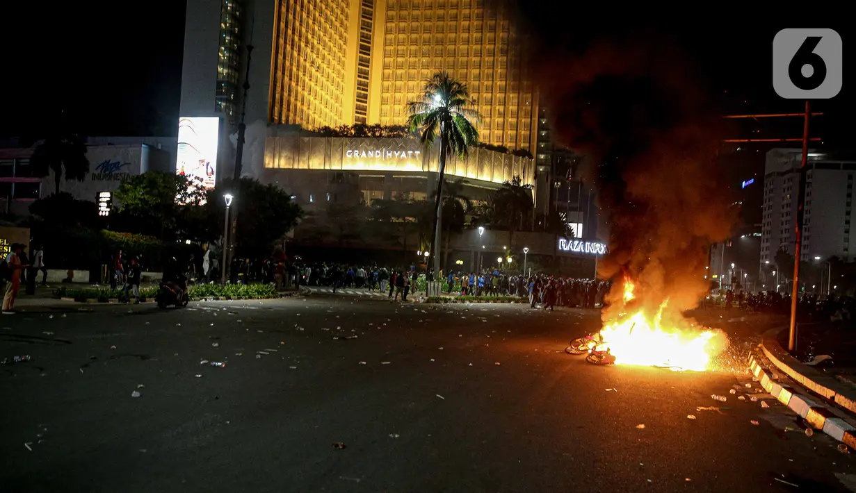 Api membakar sejumlah barang usai demonstrasi yang berujung anarkis di kawasan Bundaran HI, Jakarta, Kamis (8/10/2020). Massa membakar sejumlah barang saat demonstrasi menolak pengesahan UU Cipta Kerja. (Liputan6.com/Faizal Fanani)
