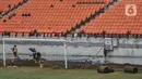 Aktivitas pekerja menyelesaikan pemasangan rumput lapangan utama Jakarta Internasional Stadium (JIS), Papanggo, Jakarta Utara, Selasa (11/1/2022). Progres pembangunan stadion terbesar di Asia yang dirancang sesuai standar FIFA tersebut saat ini mencapai 93,85 persen. (merdeka.com/Iqbal S. Nugroho)