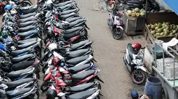 Seorang pedagang melewati lokasi parkir PD Pasar Jaya Tanah Abang, Jakarta, Senin (1/8). Mulai Agustus, Pemprov DKI melalui Badan Layanan Umum Daerah (BLUD) Perparkiran mengambil alih pengelolaan parkir 15 pasar PD Pasar Jaya. (Liputan6.com/Yoppy Renato)