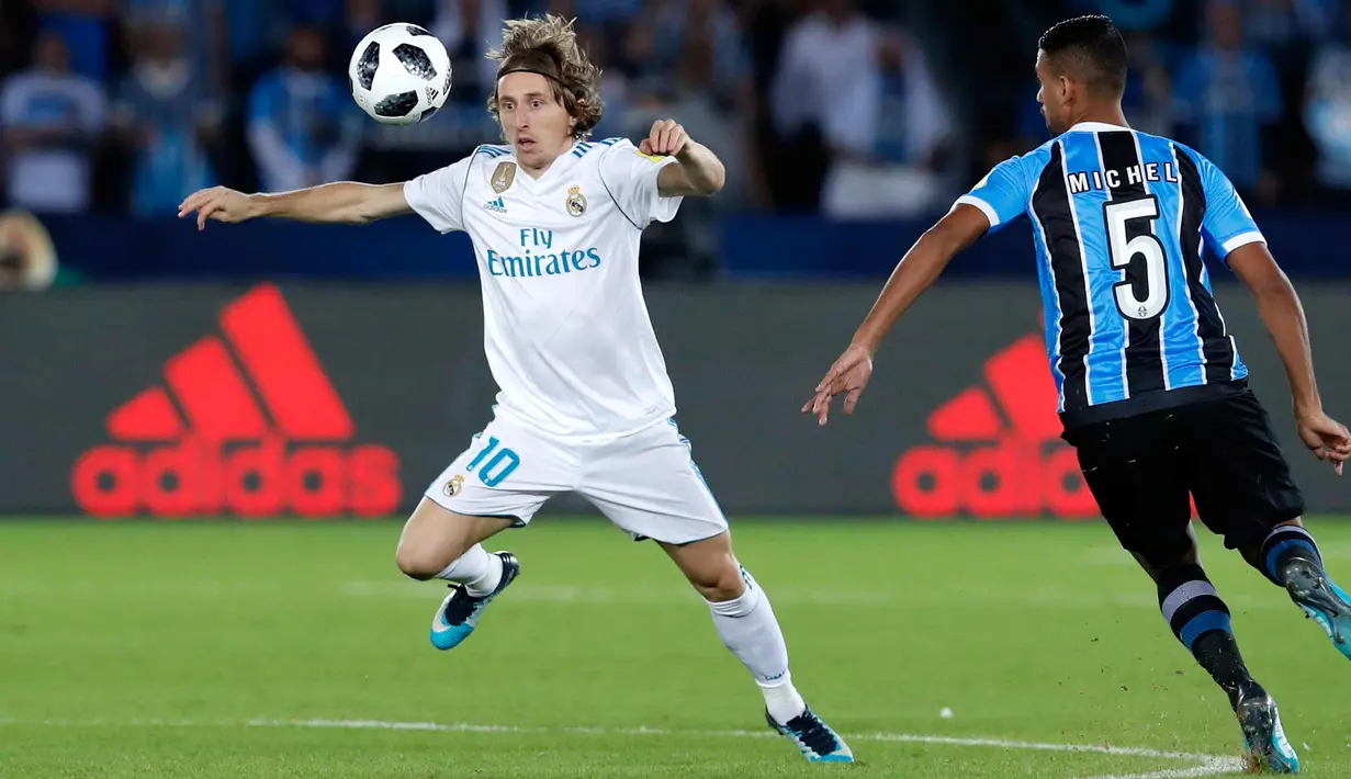 Gelandang Real Madrid, Luca Modric berusaha mengontrol bola dari kawalan pemain Gremio, Michel saat bertanding di pertandingan final Piala Dunia Antarklub 2017 di stadion Zayed Sports City di Abu Dhabi, Uni Emirat Arab, (16/12). (AP Photo / Hassan Ammar)