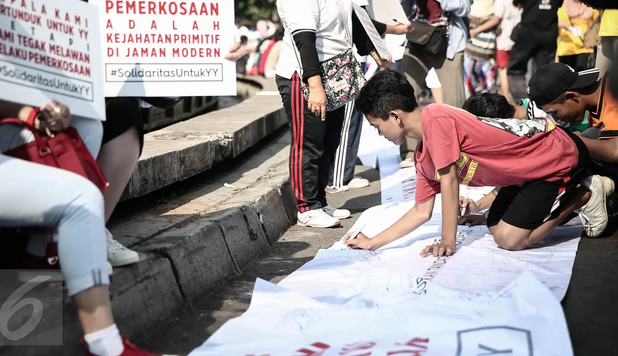 Seorang warga menandatangi spanduk aksi solidaritas untuk Yuyun disela kegiatan car free day di Bundaran HI, Jakarta, Minggu (8/5). Aksi solidaritas tersebut pun berlangsung serentak di 13 kota lainnya. (Liputan6.com/Faizal Fanani)