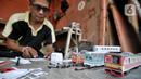 Iskandar (52) saat menyelesaikan pembuatan miniatur kereta api di kawasan Manggarai, Jakarta, Kamis (21/11/2019). Sudah 6 tahun bapak dari 2 anak ini menekuni profesi sebagai pembuat miniatur kereta api berbagai jenis, mulai dari KRL, kereta jarak jauh, hingga MRT. (merdeka.com/Iqbal S. Nugroho)