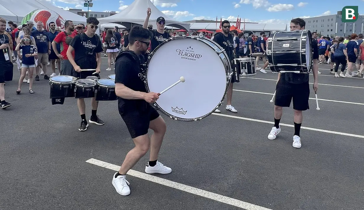 Grup penabuh drum tampil menghibur suporter di area fanzone Gillette Stadium, Foxborough, Amerika Serikat, Jumat (19/6/2026), menjelang pertandingan Skotlandia melawan Maroko pada Piala Dunia 2026. Irama tabuhan drum menciptakan suasana meriah dan membakar semangat para suporter yang memadati kawasan stadion. (KLY Sports/Hery Kurniawan)