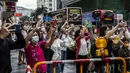 Orang-orang melambai saat anggota delegasi Olimpiade ambil bagian dalam parade bus, setelah Olimpiade Tokyo 2020, di Hong Kong, Kamis (19/8/2021). Hong Kong yang memiliki 46 atlet perwakilan pada Olimpiade Tokyo 2020 berhasil mengumpulkan satu emas, dua perak dan tiga perunggu. (ISAAC LAWRENCE/AFP)