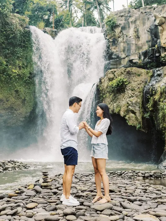 Dilamar Jesse Choi di depan air terjun, Maudy tampil cantik mengenakan blouse dan celana jeans pendek. Sementara Jesse mengenakan kemeja putih dan celana pendek hitam. [@maudyayunda].