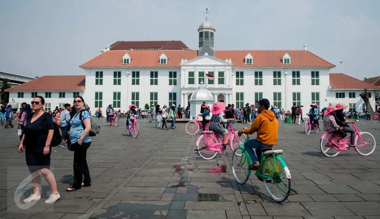 Warga berwisata menaiki sepeda kuno di kawasan Kota Tua, Jakarta, Senin (5/1). Meskipun libur panjang akan berakhir, warga tetap memadati kawasan wisata Kota Tua. (Liputan6.com/Gempur M Surya)