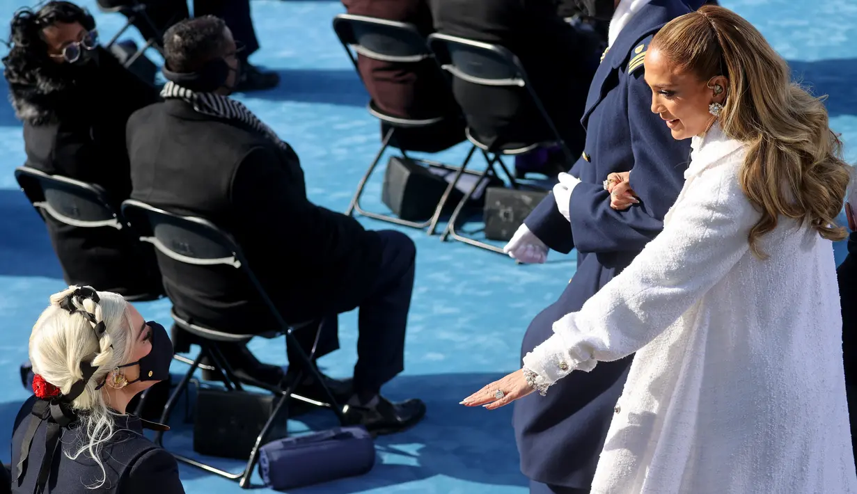 Penyanyi Jennifer Lopez menyapa Lady Gaga saat pelantikan Presiden terpilih Joe Biden di Front Barat Capitol AS di Washington, DC (20/1/2021). (Jonathan Ernst-Pool/Getty Images/AFP)
