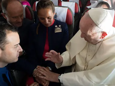 Paus Fransiskus (kanan) menikahkan pramugari Paula Podest dan Carlos Ciuffardi di atas pesawat selama penerbangan di Santiago dan kota Iquique (18/1). Pasangan ini merasakan pemberkatan pernikahan di ketinggian 10.900 meter. (HO/Osservatore Romano/AFP)