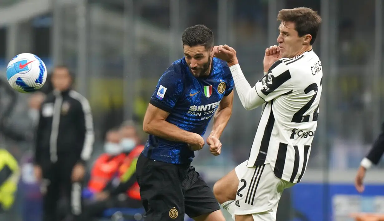 Pemain Juventus Federico Chiesa (kanan) berebut bola dengan pemain Inter Milan Roberto Gagliardini pada pertandingan Serie A di Stadion San Siro, Milan, Italia, Minggu (24/10/2021). Pertandingan berakhir dengan skor 1-1. (AP Photo/Luca Bruno)